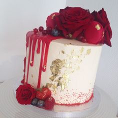 a white and red cake with roses on top