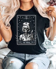 Embrace a unique blend of gothic humor and medical appreciation with our Nurse Skeleton Tarot Card T-Shirt. Featuring an intricate vintage art style, this tee makes the perfect standout piece for anyone in the healthcare field or those who love unique artistic designs. It's a great gift for nurses, medical professionals, and tarot card enthusiasts. This shirt showcases a blend of spooky and stylish, making it a conversation starter and a trendy addition to any wardrobe. PRODUCTION TIME: 2-4 busi Gothic Humor, Skeleton Tarot, Tarot Card Shirt, Gift For Nurse, Nurse Appreciation, Nurse Practitioner, Work Shirt, Prism Color, Funny Halloween