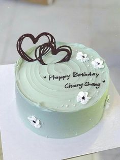 a birthday cake with white frosting and chocolate hearts on top that reads happy birthday, hong kong