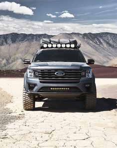 the front end of a silver truck with lights on it's headlamps