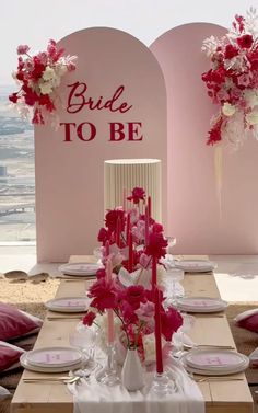 the table is set with pink and white flowers