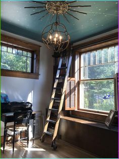 a ladder that is next to a window in a room with blue walls and windows