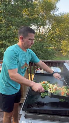 a man cooking food on top of an outdoor grill