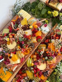 two trays filled with different types of fruit and cheese on top of each other