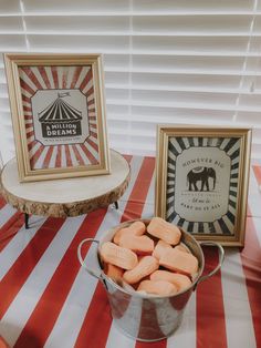 an elephant themed birthday party with candies in a bucket and framed pictures on the table