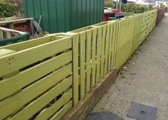 a yellow fence is next to a green building