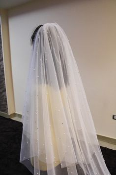 a white veil on top of a mannequin's head in a room