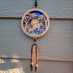 a wind chime hanging from the side of a building with an elephant design on it