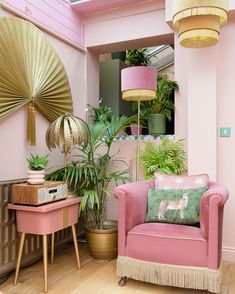 a living room with pink furniture and gold fan decorating the walls, floor, and ceiling