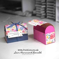 two small boxes with flowers on them are sitting next to each other, one is open and the other has a card in it