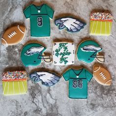 decorated cookies are arranged in the shape of footballs and jerseys