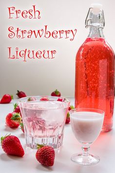 fresh strawberry liquer in a glass next to a bottle of liquid and strawberries