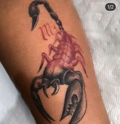 a tattoo on the arm of a man with scorpion and skull design in red ink