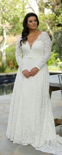 a woman in a white dress standing next to a pool