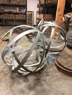 two metal balls sitting on top of a floor next to stacks of wooden pallets