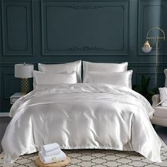 a bed with white sheets and pillows in a room