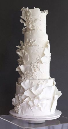 a three tiered white wedding cake sitting on top of a table