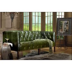 a green leather couch sitting in a living room