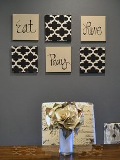 a vase with flowers sitting on top of a wooden table next to four pictures that say eat pray