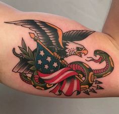 an eagle and snake with the american flag on it's arm, done by tattoo artist