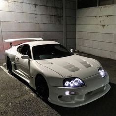 a white sports car parked in a parking garage