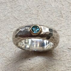 a silver ring with a blue stone in it