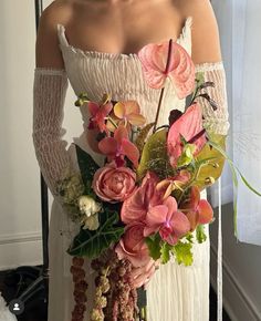 a woman in white dress holding a bouquet of flowers