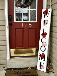 a welcome sign sitting in front of a red door