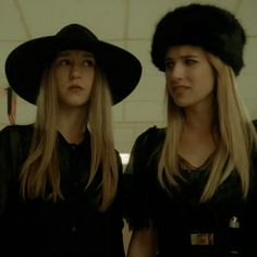 two women wearing black hats standing next to each other