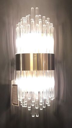 a wall light that is made out of glass tubes and some kind of metal tube