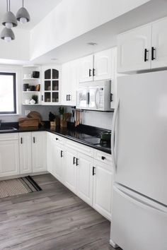 a kitchen with white cabinets and black counter tops is seen in this image from the front view