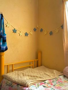 there is a bed in the room with blue and yellow stars hanging on the wall