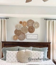 a bed room with a neatly made bed and two fan mounted on the wall above it