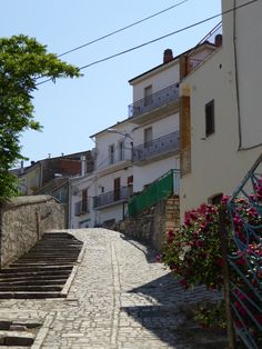 an old cobblestone street with stairs leading up to the building next to it