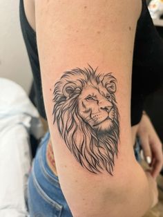 a woman's arm with a tattoo of a lion on the back of her shoulder