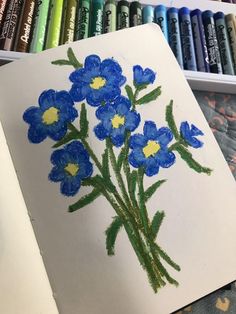 the blue flowers are drawn on paper with crayons