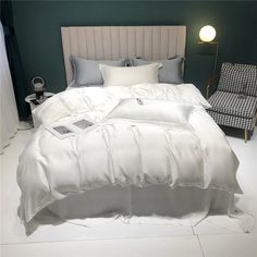 a bed with white sheets and pillows in a room