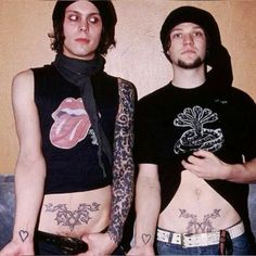 two men with tattoos standing next to each other