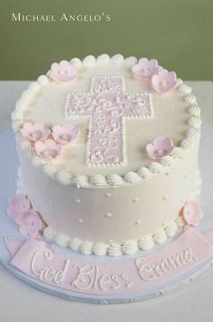 a white cake with pink flowers and a cross on top that says god's grace