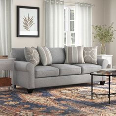 a living room scene with focus on the couch and rug, window to the side