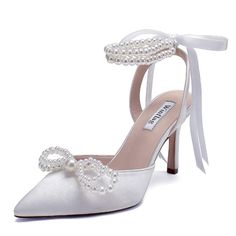 a white high heeled shoe with pearls on the ankle