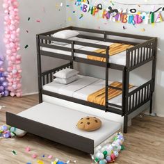 a bunk bed sitting on top of a wooden floor next to balloons and confetti