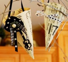 two paper umbrellas hanging from a tree branch with music notes on them and polka dots