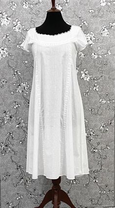 This charming vintage Victorian nightgown is crafted from 100% white cotton, offering both comfort and a touch of classic elegance. Featuring short sleeves, it blends historical style with modern convenience. The soft, breathable fabric is perfect for a restful night's sleep, while delicate Victorian details such as lace trims or embroidered accents add a timeless touch to White Cotton Short Sleeve Nightgown, White Short Sleeve Nightgown For Bedtime, White Short Sleeve Loungewear Dress, White Short Sleeve Nightgown For Sleep, White Classic Sleepwear For Spring, White Short Sleeve Bedtime Dress, Classic White Cotton Sleepwear, White Short Sleeve Nightgown For Loungewear, Solid Color Spring Nightgown For Daywear