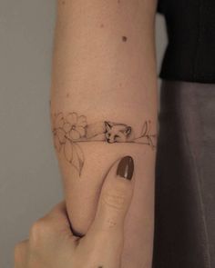 a woman's arm with a cat tattoo on the left side of her body