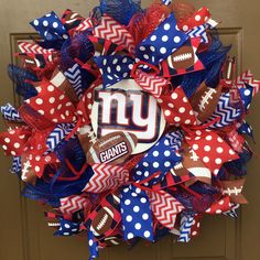 a new york giants mesh wreath with footballs and polka dots on the front door