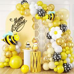 a birthday party with balloons and honeybees on the wall, cake table and decorations