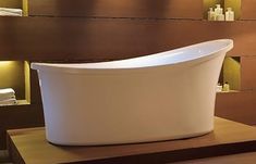 a white bath tub sitting on top of a wooden table