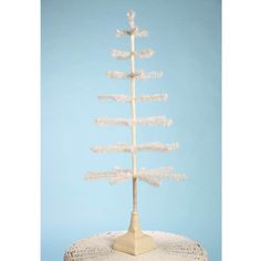 a small white christmas tree sitting on top of a table