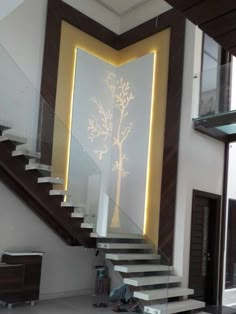 there is a stair case with a tree on it next to the stairs in this house